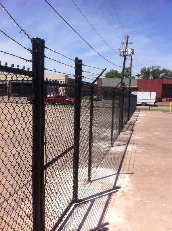 black chain link fence with barbed wire protecting a business