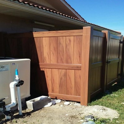 dark brown vinyl fence six feet tall around a suburban home