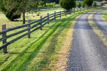 split rail cedar fence along a gravel driveway
