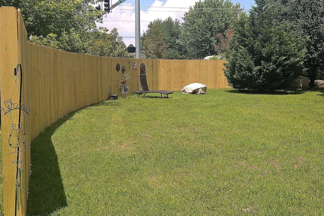 wood privacy fence surrounding a yard on a busy street
